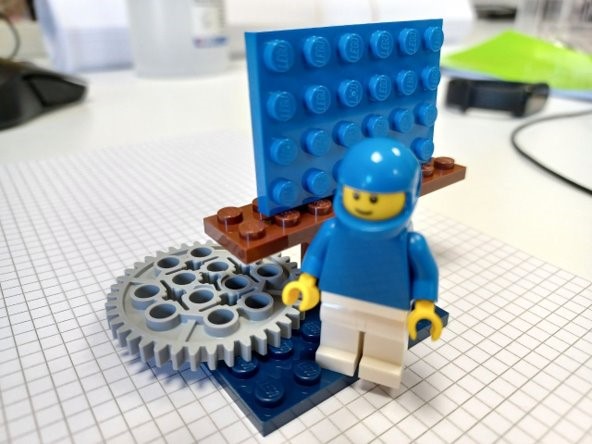 omino con casco e ingranaggio costruiti con mattoncini Lego